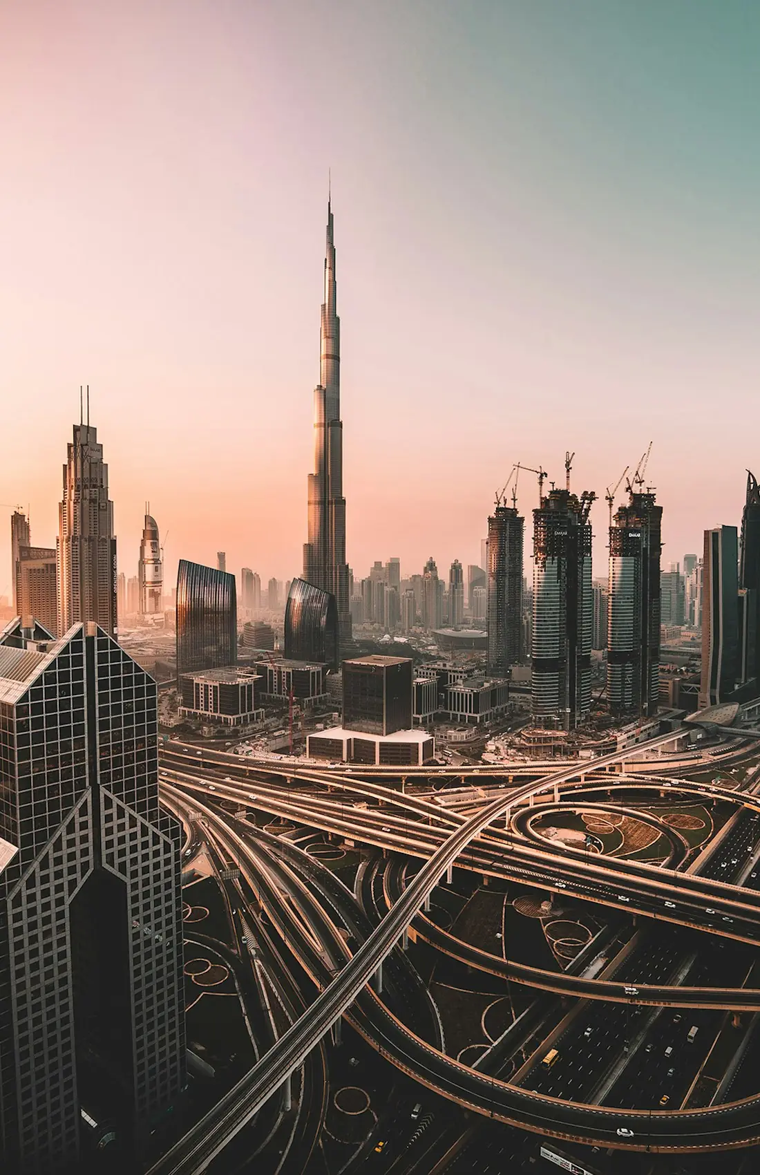 Dubai at sunset, the Burj Khalifa rising above the Sheikh Zayed Road interchange